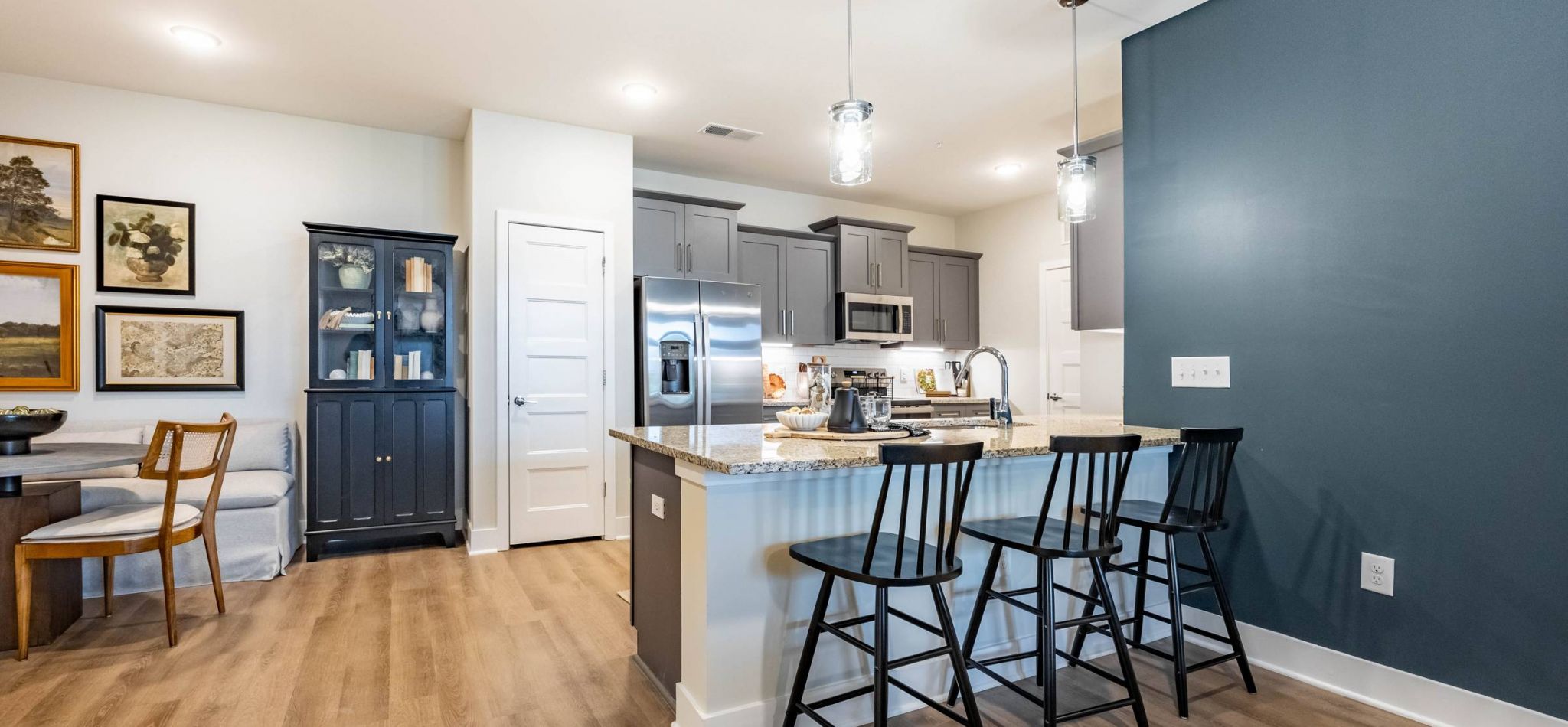 Hawthorne at Brightwood Farm contemporary kitchen with a central island, granite countertops, and pendant lights, complemented by stainless steel appliances and wooden flooring.